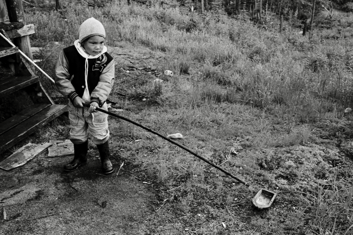 Enfant Atikamekw jouant avec un canot miniature